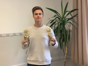 Timur Zolotar mit zwei Pokalen, die er beim internationalen Dame-Turnier gewonnen hat