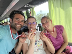 Betreuerinnen und Betreuer des Teams mit Medaillen im Bus 