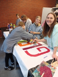 Ann-Lena Bill mit Kindern aus der Nachmittagsbetreuung beim Gestalten der Bettlaken 