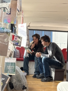 Zwei Schüler nutzen im oberen Stockwerk das Hörangebot 